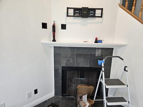 TV installation above fireplace with clean cable management